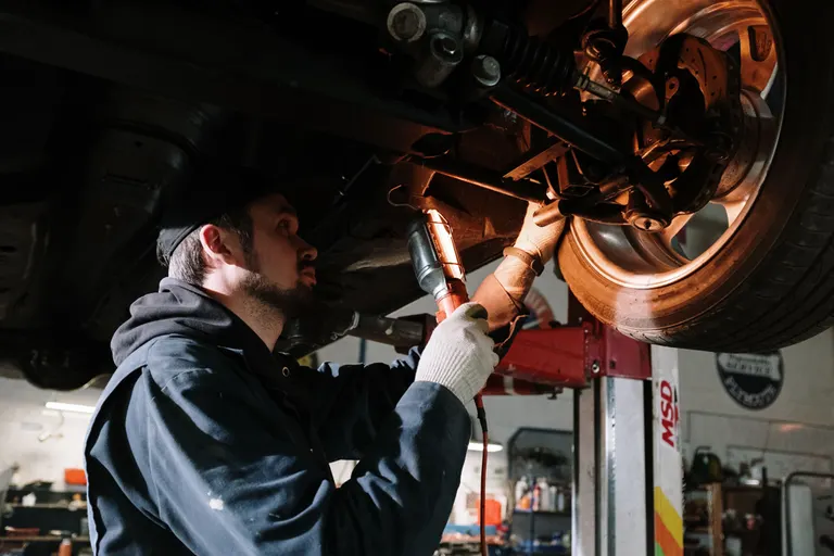 Mechanik wykonujący naprawę samochodu na podnośniku