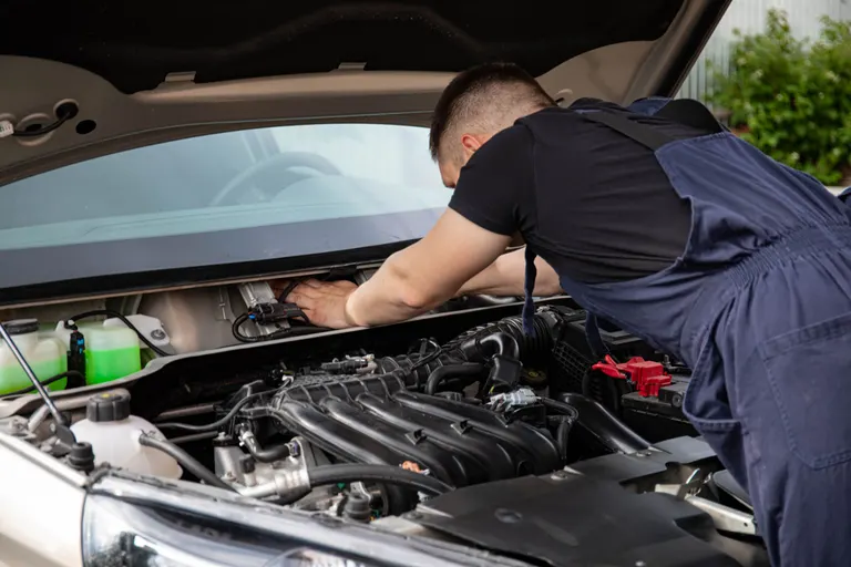 Mechanik wykonujący prace przy silniku samochodu