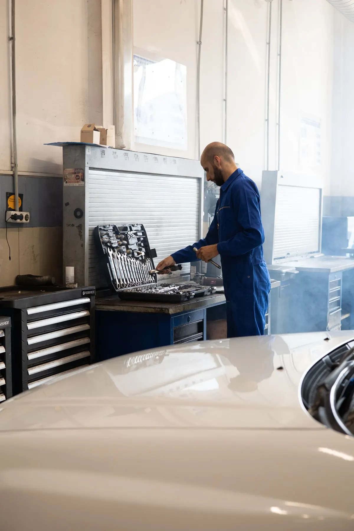 Mechanik dobiera narzędzia z szafki warsztatowej